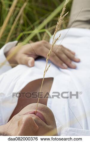 Man with sprig of weed in mouth, close-up View Large Photo Image Stock Photograph - Man with sprig of weed in mouth, close-up. Fotosearch