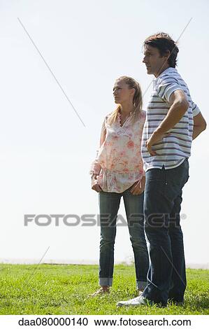 Stock Image - Mature couple standing on meadow. Fotosearch