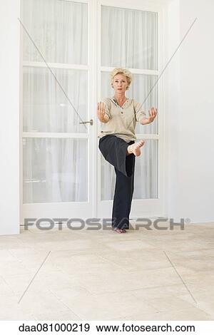 Mature woman balancing on one leg while exercising View Large Photo Image Stock Photo - Mature woman balancing on one leg while exercising. Fotosearch