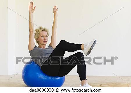 Mature woman doing pilates exercise on fitness ball View Large Photo Image Stock Image - Mature woman doing pilates exercise on fitness ball. Fotosearch