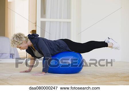 Mature woman doing pilates exercise on fitness ball View Large Photo Image Stock Photo - Mature woman doing pilates exercise on fitness ball. Fotosearch