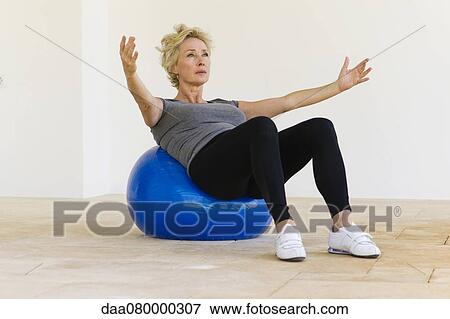 Mature woman doing pilates exercise on fitness ball View Large Photo Image Stock Photo - Mature woman doing pilates exercise on fitness ball. Fotosearch