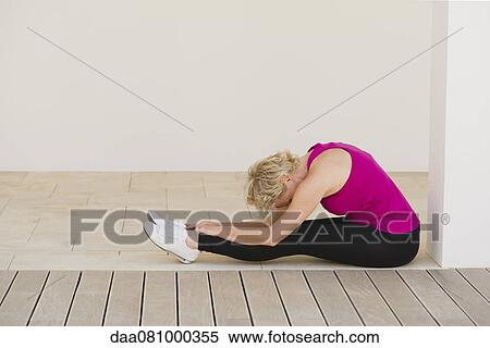 Mature woman doing seated forward bend pose View Large Photo Image Stock Photography - Mature woman doing seated forward bend pose. Fotosearch