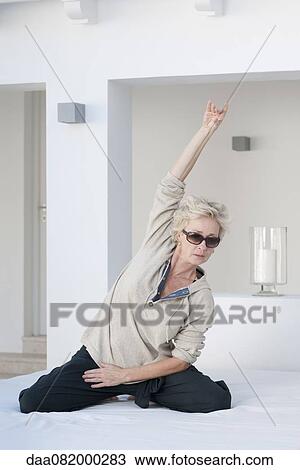 Mature woman exercising on bed outdoors View Large Photo Image Stock Image - Mature woman exercising on bed outdoors. Fotosearch