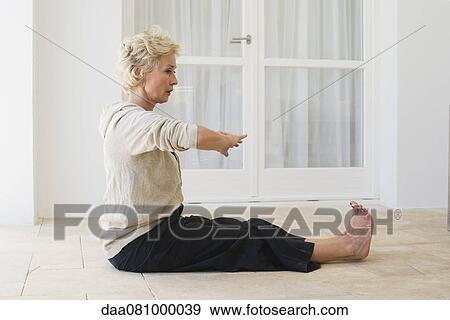 Mature woman practicing yoga on floor View Large Photo Image Stock Photo - Mature woman practicing yoga on floor. Fotosearch