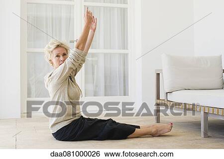 Mature woman practicing yoga on floor View Large Photo Image Stock Photograph - Mature woman practicing yoga on floor. Fotosearch