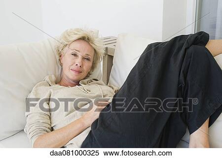 Mature woman reclining on sofa View Large Photo Image Stock Photography - Mature woman reclining on sofa. Fotosearch