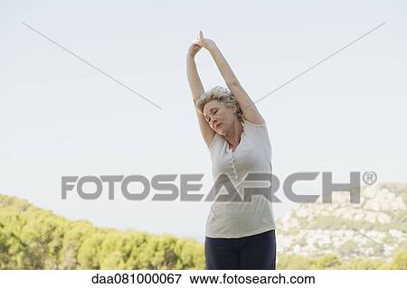Stock Photo - Mature woman stretching arms. Fotosearch