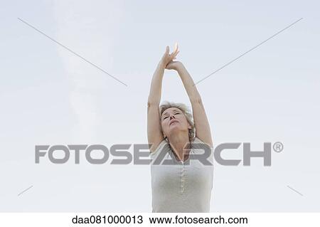 Mature woman stretching arms with arms closed View Large Photo Image Stock Image - Mature woman stretching arms with arms closed. Fotosearch