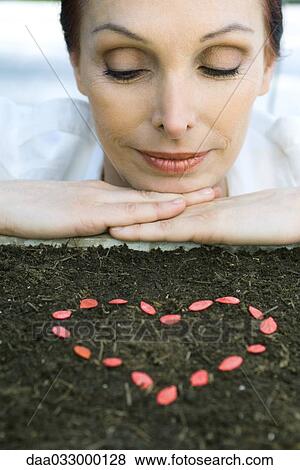 Stock Photo - Mature woman with seeds in shape of heart. Fotosearch