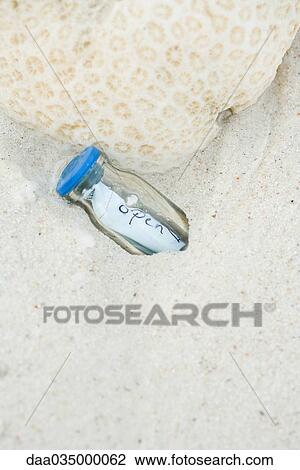 Message in a bottle, partially buried in sand View Large Photo Image Stock Image - Message in a bottle, partially buried in sand. Fotosearch
