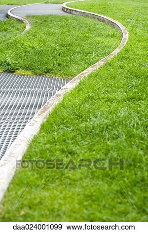 Metal grate and concrete curves in grass View Large Photo Image Stock Photo - Metal grate and concrete curves in grass. Fotosearch
