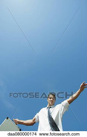 Mid-adult businessman carrying briefcase, low angle view View Large Photo Image Picture - Mid-adult businessman carrying briefcase, low angle view. Fotosearch