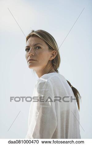 Mid-adult woman looking over shoulder View Large Photo Image Stock Image - Mid-adult woman looking over shoulder. Fotosearch