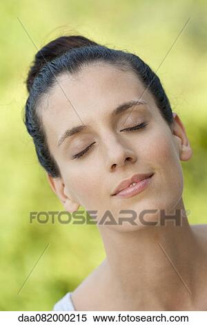 Stock Photography - Mid-adult woman with eyes closed, smiling. Fotosearch