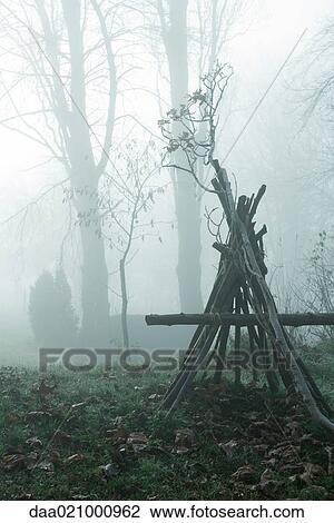 Misty landscape with teepee-shaped log structure in foreground View Large Photo Image Stock Image - Misty landscape with teepee-shaped log structure in foreground. Fotosearch