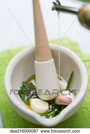 Mortar and pestle with herbs, olive oil and garlic View Large Photo Image Stock Photo - Mortar and pestle with herbs, olive oil and garlic. Fotosearch