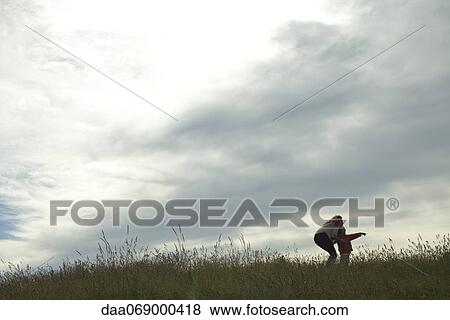 Mother and child standing in meadow, looking at something in the distance View Large Photo Image Stock Photo - Mother and child standing in meadow, looking at something in the distance. Fotosearch