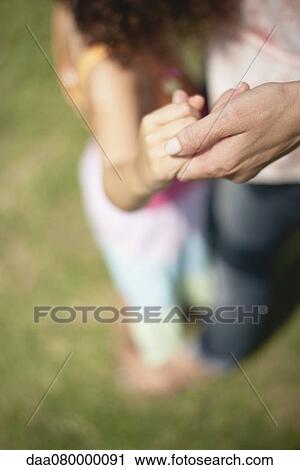 Stock Image - Mother and daughter holding hands, cropped. Fotosearch