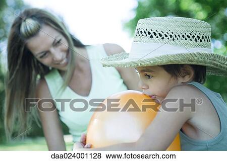 Mother and son, boy blowing up balloon while mother watches View Large Photo Image Stock Photo - Mother and son, boy blowing up balloon while mother watches. Fotosearch