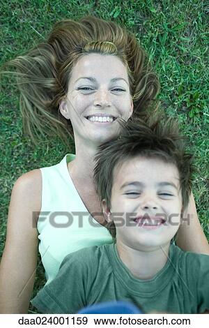 Mother and son, boy lying on top of woman, laughing, lying on grass, high angle view View Large Photo Image Stock Photo - Mother and son, boy lying on top of woman, laughing, lying on grass, high angle view. Fotosearch
