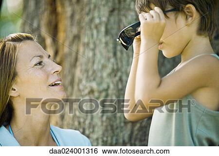 Mother and son, boy putting on sunglasses View Large Photo Image Stock Photograph - Mother and son, boy putting on sunglasses. Fotosearch