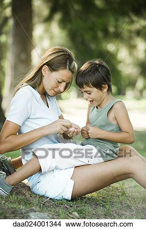 Picture - Mother and son sitting outdoors, playing together. Fotosearch