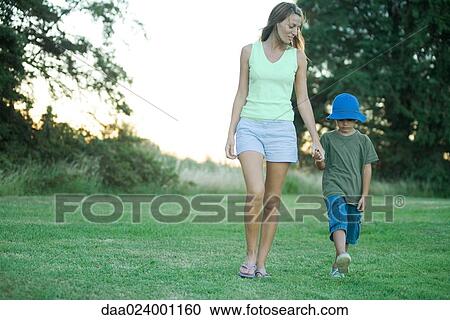 Stock Image - Mother and son, walking hand in hand. Fotosearch
