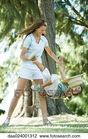 Mother and son, woman holding boy by arm and leg, swinging him around View Large Photo Image Stock Image - Mother and son, woman holding boy by arm and leg, swinging him around. Fotosearch