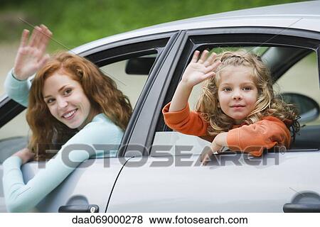 Mother and young daughter leaning out of car windows, waving View Large Photo Image Stock Photo - Mother and young daughter leaning out of car windows, waving. Fotosearch