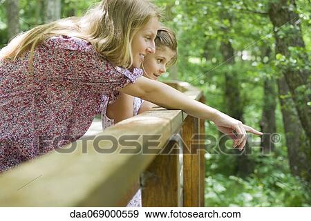 Mother and young daughter looking over railing together View Large Photo Image Stock Photo - Mother and young daughter looking over railing together. Fotosearch