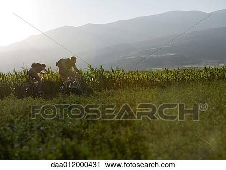 Stock Image - Mountain bikers in mountainous landscape. Fotosearch