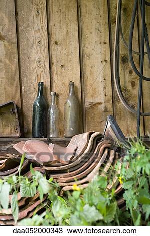 Old glass bottles, broken clay tiles stacked by wall outdoors View Large Photo Image Stock Image - Old glass bottles, broken clay tiles stacked by wall outdoors. Fotosearch