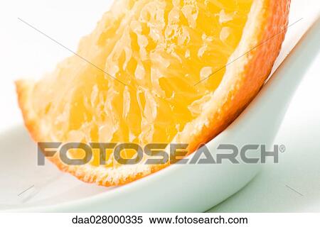 Stock Photography - Orange slice in small dish, close-up. Fotosearch