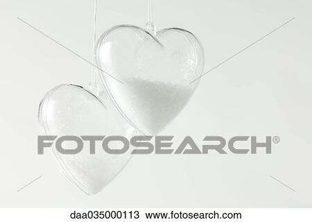 Pair of heart-shaped glass ornaments partially filled with snow View Large Photo Image Stock Image - Pair of heart-shaped glass ornaments partially filled with snow. Fotosearch