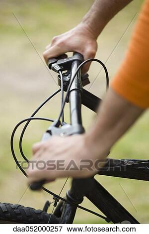 Stock Photo - Person riding bicycle, cropped view. Fotosearch