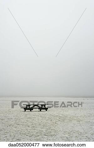 Stock Photo - Picnic table on empty, foggy beach. Fotosearch
