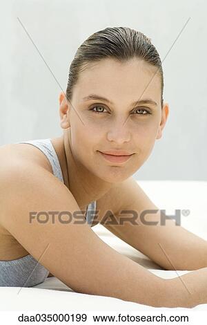 Portrait of young woman lying on futon, leaning on elbows View Large Photo Image Stock Photo - Portrait of young woman lying on futon, leaning on elbows. Fotosearch