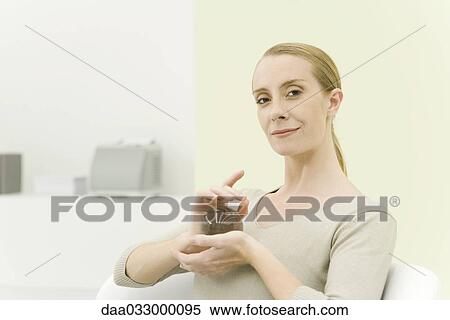 Stock Photography - Professional woman holding crystal ball, smiling at camera. Fotosearch
