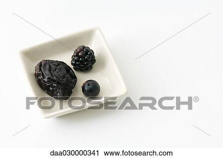 Stock Image - Prune, blackberry, and blueberry in dish. Fotosearch