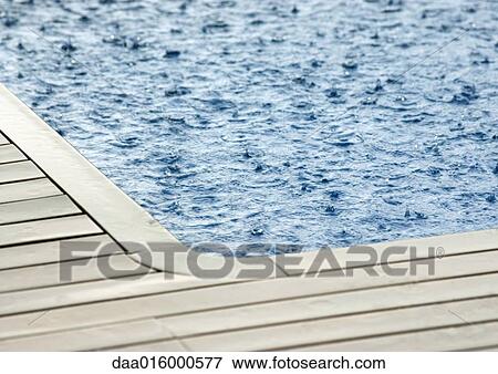Rain falling on surface of swimming pool View Large Photo Image Stock Photo - Rain falling on surface of swimming pool. Fotosearch