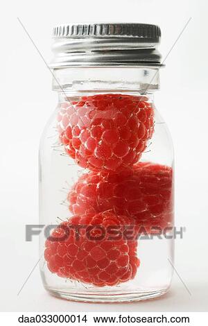 Picture - Raspberries in small jar, close-up. Fotosearch