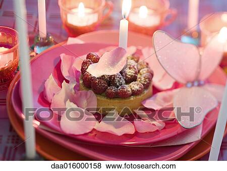 Raspberry pastry on plate decorated with rose petals and candles View Large Photo Image Stock Photo - Raspberry pastry on plate decorated with rose petals and candles. Fotosearch