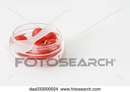 Red berries in cosmetic container, small plastic spatula lying across jar View Large Photo Image Picture - Red berries in cosmetic container, small plastic spatula lying across jar. Fotosearch