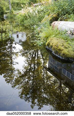 Reflection of house and trees on still surface of lake View Large Photo Image Stock Photo - Reflection of house and trees on still surface of lake. Fotosearch