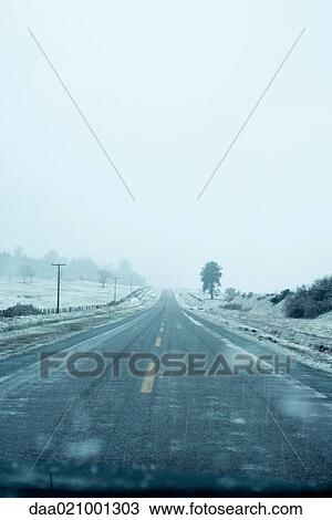 Stock Image - Road going through snowy landscape. Fotosearch