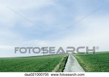 Road through green fields, tower in distance View Large Photo Image Stock Photography - Road through green fields, tower in distance. Fotosearch