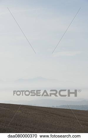 Rural field with fog and mountains in the distance View Large Photo Image Stock Image - Rural field with fog and mountains in the distance. Fotosearch