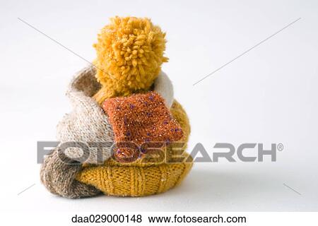 Stock Photo - Scarf wrapped around knit hat, close-up. Fotosearch