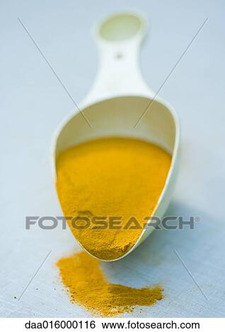 Stock Photograph - Scoop full of turmeric. Fotosearch
